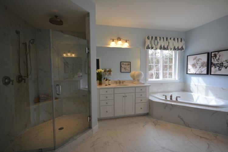 The master bathroom has ceramic tile flooring and shower and bathtub surrounds.