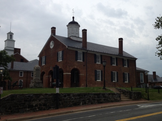 On April 25, 1861, the Fairfax Riflemen of the Confederacy were organized at Fairfax Courthouse, and on May 23, voters here ratified the Ordinance of Secession, 151 to 8. Before dawn on June 1, Lieutenant Charles Tompkins led the 2nd New York Cavalry in an unsuccessful attack on three Confederate units here. Captain John Quincy Marr of the Warrenton Rifles, died during the attack. He was the first Confederate officer killed in the Civil War. The courthouse changed hands that summer, when General Irvin McDowell raised the Union flag atop it on July 17. The Confederate flag replaced the Stars and Stripes five days later during the Union retreat after the First Battle of Manassas. On October 3, following a conference of Confederate leaders in the courthouse, President Jefferson Davis reviewed 30,000 troops here. When the Confederates evacuated northern Virginia in March 1862, Union General George B. McClellan launched his campaign to capture Richmond from his headquarters nearby on March 14. In December, Lieutenant Colonel Charles Cummings, 16th Vermont Infantry, took “peaceable possession” of the clerk’s office and the courthouse, which was used for storage. He wrote that “windows were broken out and boarded up and the inside ripped out and the walls defaced. The green was trodden up, encamped upon and besmeared.” On March 9, 1863, Lt. John S. Mosby and his Rangers rode into a nearby Union camp near midnight and kidnapped Gen. Edwin H. Stoughton in the war’s most audacious act here.